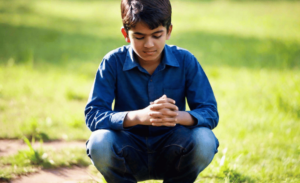 a picture of a young boy praying on a field